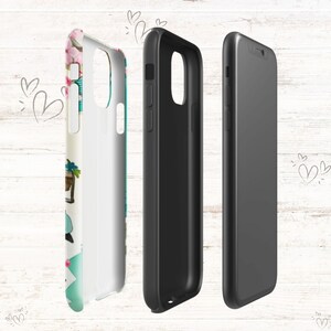 Op de afbeelding: Een telefoonhoesje met een bloemenontwerp met roze bloemen, groene bladeren en een blauwe vogel. Het hoesje wordt in drie verschillende weergaven getoond: voor, achter en zijkant. Het hoesje is gemaakt van hard plastic en heeft een transparante achterkant.