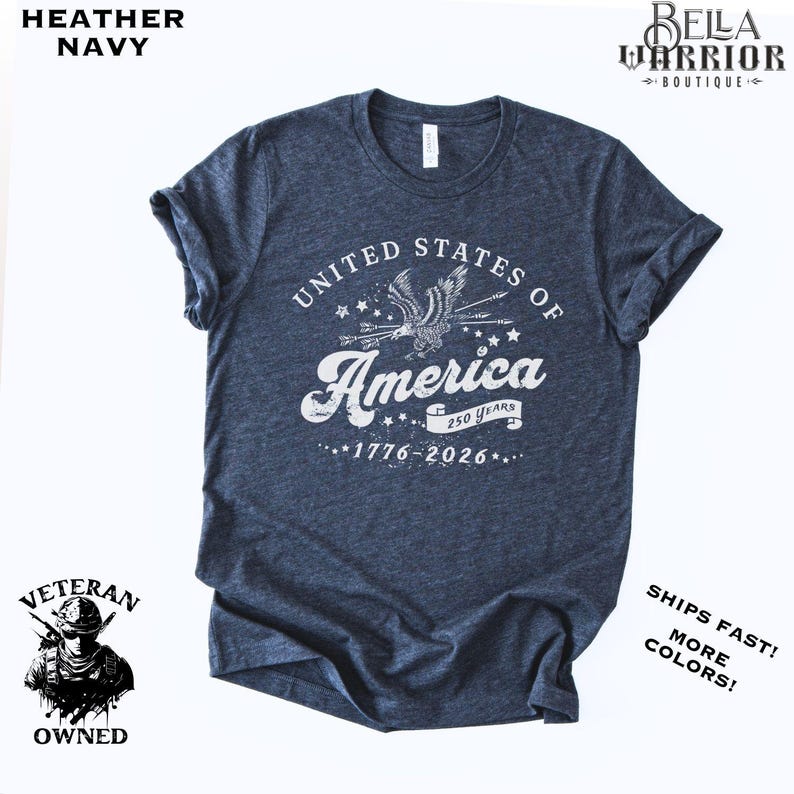 Puede incluir: Camiseta azul marino jaspeada con un dise&ntilde;o blanco que dice "United States of America" con un &aacute;guila y estrellas. El texto "250 Years 1776-2026" tambi&eacute;n est&aacute; impreso. De Bella Warrior Boutique.