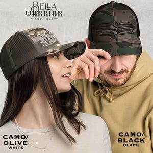 May include: Two camouflage trucker hats. One hat is camo/olive with a white front, the other is camo/black with a black front. The hats have a mesh back and a curved brim. The text "BELLA WARRIOR BOUTIQUE" is at the top.