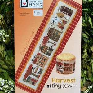 Può includere: Uno schema di ricamo a punto croce per una piccola scena di paese con case, alberi e zucche. Lo schema si chiama "Harvest Tiny Town" ed è di Heart in Hand Needlearts. Il prezzo è di 13,00 €.