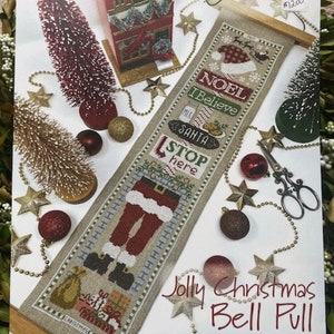 May include: A counted cross stitch pattern for a Christmas bell pull featuring a Santa Claus figure, a red and white striped stocking, and the text "NOEL", "I Believe", "SANTA", and "STOP here".