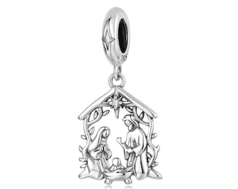 May include: A silver charm depicting the Nativity scene. The charm features a star, a roof, and the figures of Mary, Joseph, and baby Jesus. The charm is suspended from a loop with a star design.