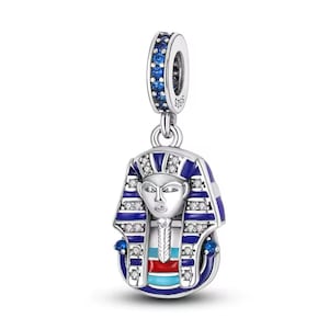 May include: Silver charm featuring a blue and white enamel depiction of an Egyptian pharaoh's mask with blue and white cubic zirconia accents.