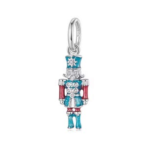 May include: A silver charm in the form of a toy soldier, with a blue and red uniform and white details. The charm has a loop for attachment and is decorated with small, clear gemstones. The soldier's hat features a star design.