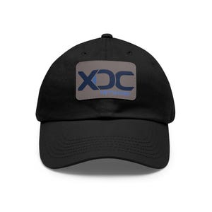 May include: Black cotton baseball cap with a brown patch featuring the text "XDC NETWORK" in blue and white lettering.
