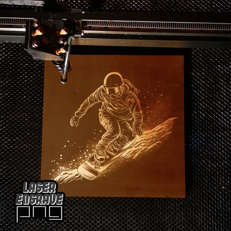 Puede incluir: Una placa de madera grabada con l&aacute;ser con un dise&ntilde;o de un snowboarder con casco y gafas, bajando por una ladera nevada. La placa tiene un fondo marr&oacute;n y el dise&ntilde;o es de color marr&oacute;n claro. El texto "LASER ENGRAVE" es visible en la esquina inferior izquierda de la placa.