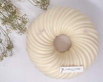 Puede incluir: Una vela blanca en forma de rosquilla, con forma de espiral. La vela tiene una etiqueta que dice "La Belle Lumière London".