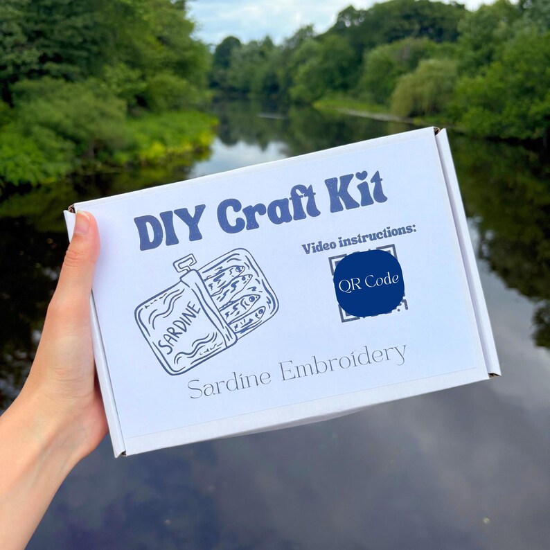 The DIY craft kit box containing the contents for the sardine embroidery kit.