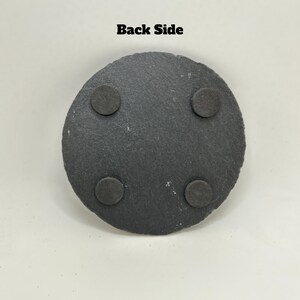 May include: Black round slate coaster with four black felt pads on the bottom. "Back Side" is written in black text at the top of the image.