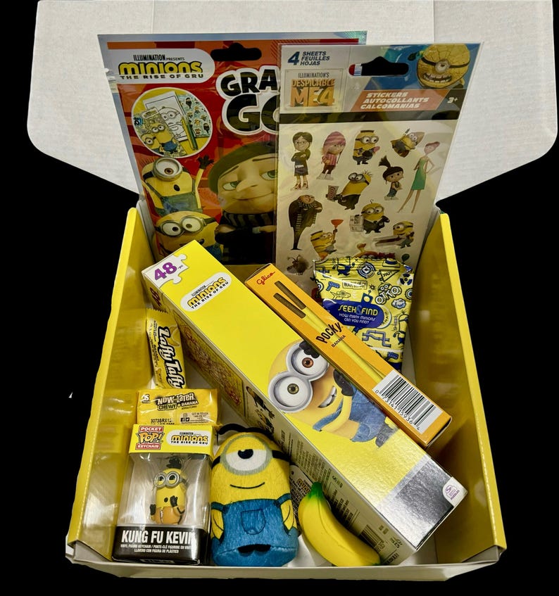 May include: A yellow box filled with Minion themed items including a coloring book, stickers, a 48 piece puzzle, a plush toy, a candy bar, a box of Pocky sticks, and a small figurine. The box is labeled "Minions: The Rise of Gru".