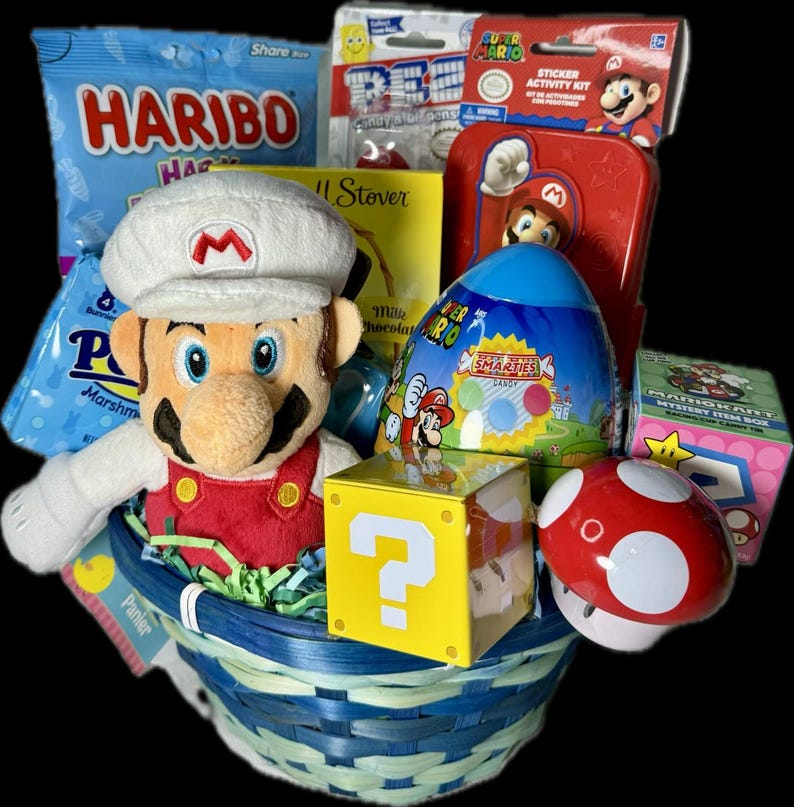 Pu&ograve; includere: Un cesto di vimini blu e bianco pieno di dolcetti pasquali a tema Super Mario. Il cesto include un pupazzo di peluche di Mario, una barretta di cioccolato, un uovo Super Mario Smarties, un blocco con punto interrogativo, un fungo rosso e un kit di attivit&agrave; con adesivi.