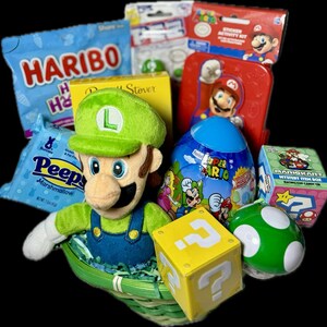 Pu&ograve; includere: Un cestino di Pasqua verde e giallo pieno di giocattoli e dolci a tema Super Mario. Il cestino include un Luigi di peluche, un uovo di Super Mario, una scatola di oggetti misteriosi di Mario Kart, un blocco con punto interrogativo e un fungo verde.