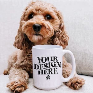 May include: A white ceramic mug with a black paw print and the text 'YOUR DESIGN HERE' in a retro font. A light brown dog is sitting next to the mug.