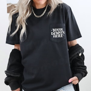 Puede incluir: Camiseta negra con un bolsillo en el lado izquierdo. El bolsillo tiene texto blanco que dice "YOUR DESIGN HERE".