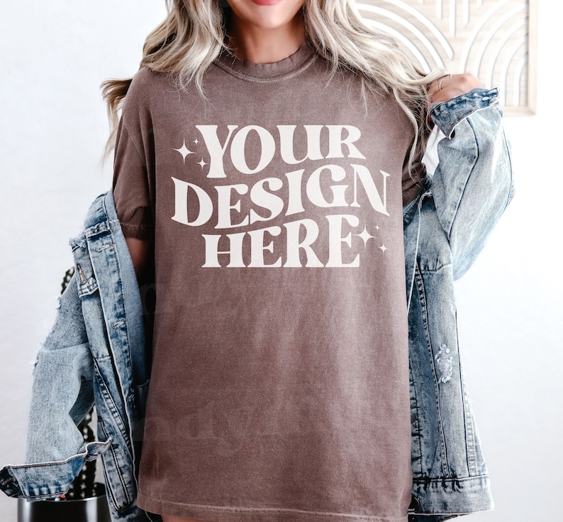 May include: A brown t-shirt with the text 'YOUR DESIGN HERE' in white lettering.