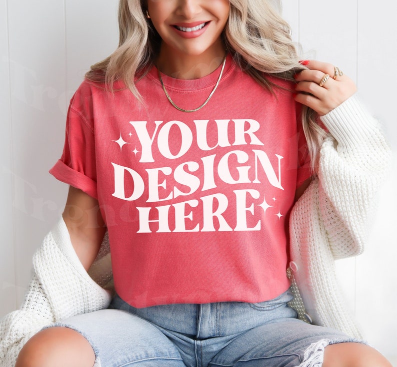 May include: A red t-shirt with white text that reads 'YOUR DESIGN HERE'.