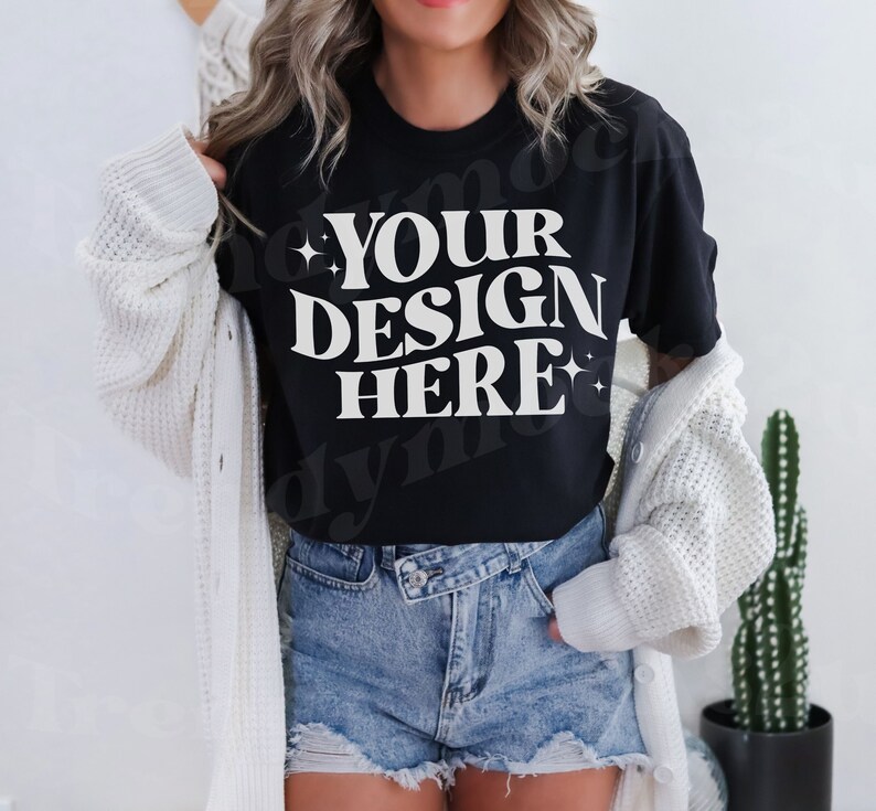May include: A black t-shirt with white text that reads 'YOUR DESIGN HERE'.