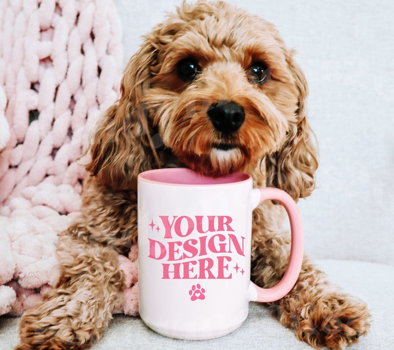 May include: A white ceramic mug with a pink rim and handle. The mug has pink text that reads 'YOUR DESIGN HERE' with a pink paw print below the text.