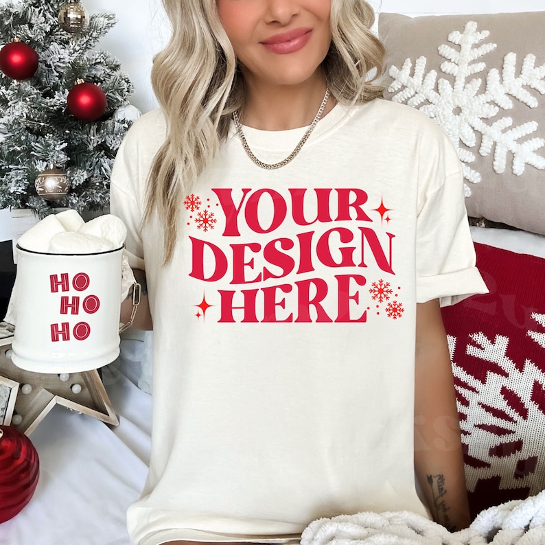 May include: A white t-shirt with a red design that says "YOUR DESIGN HERE" with snowflakes and stars around the text.
