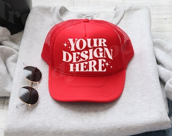 Könnte beinhalten: Rote Trucker-Kappe mit weißem Netzrücken und dem Text "YOUR DESIGN HERE" in weißen Buchstaben.