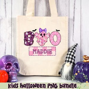Puede incluir: Un bolso tote de color crema con un dise&ntilde;o tem&aacute;tico de Halloween. La palabra "BOO" est&aacute; escrita con una "B" con estampado morado, una "O" fantasma rosa y una "O" en forma de rosquilla rosa. El nombre "MADDIE" est&aacute; debajo. Murci&eacute;lagos negros est&aacute;n arriba.