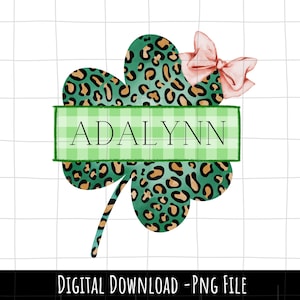 May include: A green shamrock with a leopard print design and a pink bow. The shamrock has a green and white checkered banner with the name "ADALYNN" written in white.