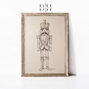 May include: A black and white pencil drawing of a nutcracker soldier in a frame. The nutcracker is wearing a tall hat with a plume, a jacket with a sash, and pants with boots. The drawing is on a beige background.