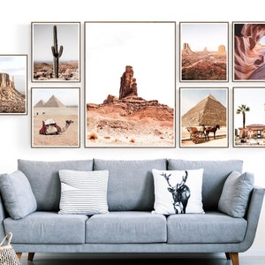 Puede incluir: Una colecci&oacute;n de impresiones enmarcadas de paisajes con escenas des&eacute;rticas, incluyendo un cactus, pir&aacute;mides y formaciones rocosas. Las impresiones se exhiben sobre un sof&aacute; gris con cojines decorativos, creando una pared de galer&iacute;a cohesiva.