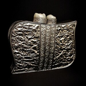 Close-up of silver leaf pattern and pearl embellishment on clutch bag
