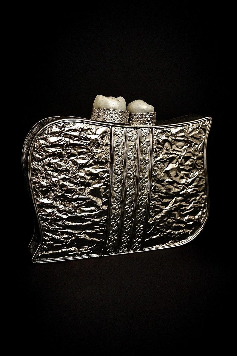 Close-up of silver leaf pattern and pearl embellishment on clutch bag