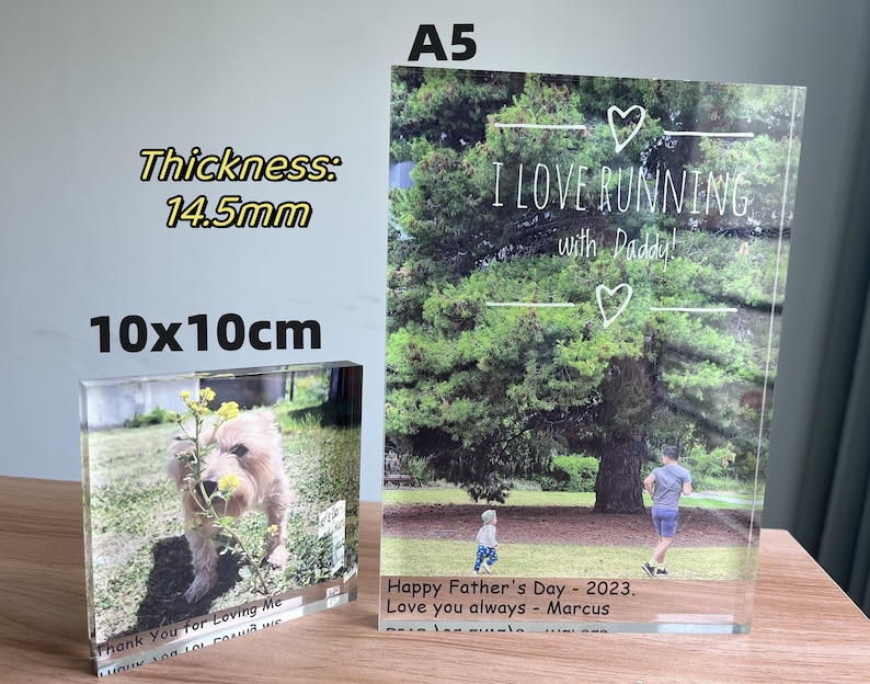 May include: Two acrylic photo blocks with images. The larger block is A5 size and features a photo of a father and son running in a park with the text "I LOVE RUNNING with Daddy!" and "Happy Father's Day - 2023. Love you always - Marcus". The smaller block is 10x10cm and features a photo of a dog in a field of yellow flowers with the text "Thank You for Loving Me".