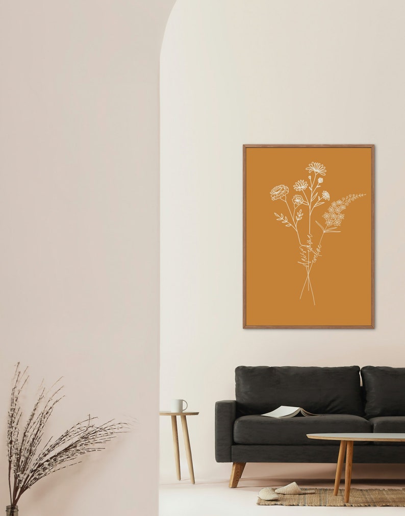 Puede incluir: Una impresi&oacute;n enmarcada con un dibujo minimalista de un ramo de flores silvestres sobre un fondo amarillo mostaza.