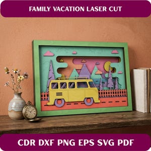 May include: A multi-layered laser-cut wooden art piece with a family vacation theme. The artwork features a yellow van, mountains, trees, and a road, all set against a colorful backdrop. The text "FAMILY VACATION LASER CUT" is at the top.