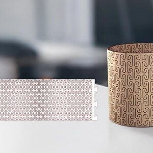 May include: A cylindrical wooden container with a repeating pattern of curved lines. Beside it, a flat, rectangular piece with the same pattern. Both items are light brown with dark brown detailing, set against a blurred background.
