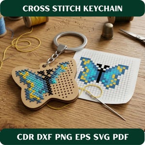 May include: A wooden butterfly-shaped cross-stitch keychain with blue, yellow, and black thread. The keychain is attached to a silver ring. The image also shows a cross-stitch pattern and the text "CROSS STITCH KEYCHAIN".