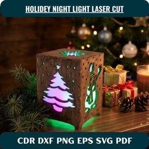 Könnte beinhalten: Eine quadratische, lasergeschnittene Nachtlichtbox aus Holz mit Ausschnitten eines Weihnachtsbaums und eines Schneemanns. Die Box strahlt ein mehrfarbiges Licht aus. Der Text HOLIDEY NIGHT LIGHT LASER CUT und CDR DXF PNG EPS SVG PDF ist sichtbar.