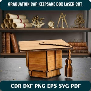 Può includere: Una scatola ricordo in legno tagliata al laser a forma di tocco di laurea, con una parte superiore quadrata piatta, un bottone centrale e una nappa pendente. La scatola presenta una finitura in legno chiaro con bordi scuri e pannelli a incastro.