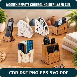 May include: A collection of wooden remote control holders featuring various laser-cut designs, including white and natural wood finishes. These organisers have multiple compartments for storing electronic remotes, with some displaying intricate floral patterns.