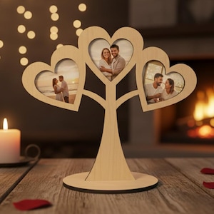 May include: A wooden photo display in the shape of a tree, featuring heart-shaped frames holding three photographs. The display sits on a wooden table with candles and rose petals, creating a romantic ambiance.