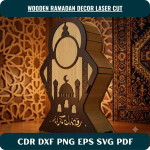 May include: A laser-cut wooden Ramadan decor piece featuring a light wood center panel and dark wood frame. The design includes a mosque silhouette with a crescent moon, star cutouts, and Arabic script text at the base. The text reads WOODEN RAMADAN DECOR LASER CUT and CDR DXF PNG EPS SVG PDF.