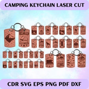 May include: A collection of laser-cut wooden camping keychains. Each keychain features a unique design with camping-themed phrases and graphics, including mountains, tents, and campfires. The keychains are attached to silver-colored key rings.