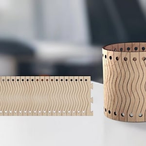 May include: A wooden cylindrical container and a flat wooden panel. Both pieces are made of light-colored wood and feature a wavy, slotted design. The container has a series of evenly spaced holes near the top and bottom edges.