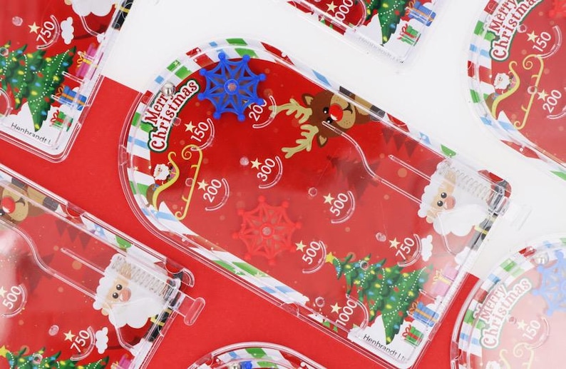 May include: Christmas-themed pinball games in red and white, featuring Santa Claus, reindeer, and Christmas trees. The games display point values and the words "Merry Christmas".