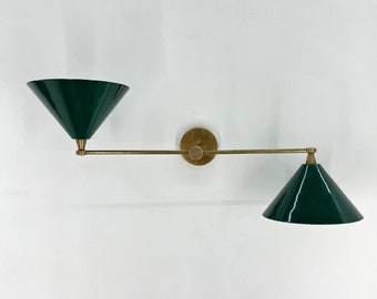 May include: A wall-mounted light fixture with two adjustable arms and green cone-shaped shades. The arms are made of brass and the shades are a dark green.
