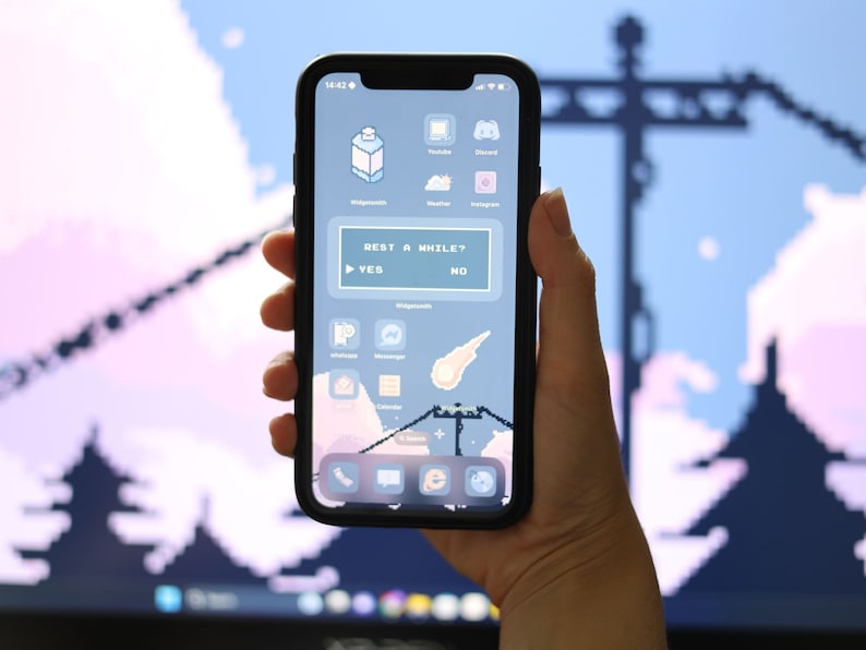 May include: A smartphone with a pixelated background and a custom home screen. The screen displays a message that reads "Rest a while?" with "Yes" and "No" buttons. The phone is held in a hand.