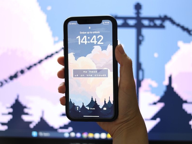 May include: A smartphone displaying a pixelated sky with clouds and the text "My head is in the clouds". The time on the screen is 14:42.