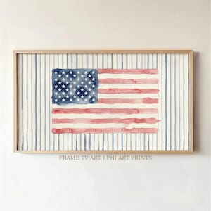 Op de afbeelding: Een rechthoekig ingelijst kunstwerk aan de muur met een aquarel van de vlag van de Verenigde Staten, gecentreerd over een achtergrond van verticale blauwe strepen op een crèmekleurig veld. De tekst FRAME TV ART I PHI ART PRINTS staat onderaan.