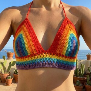 Front view of a vibrant pride rainbow-striped crochet halter top with a deep V-neckline, showcasing colorful handmade knitwear for summer or festival wear.