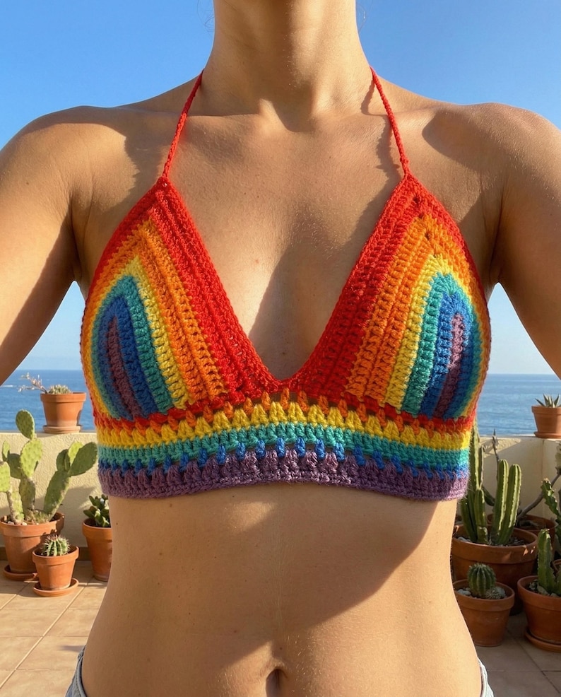 Front view of a vibrant pride rainbow-striped crochet halter top with a deep V-neckline, showcasing colorful handmade knitwear for summer or festival wear.