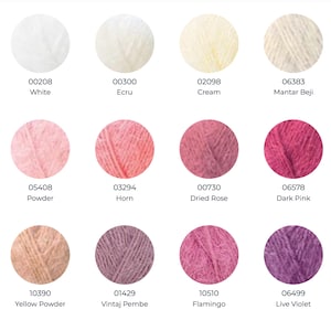 May include: A color chart featuring twelve circular swatches of fuzzy yarn in various shades. The colors include white, ecru, cream, mantar beji, powder, horn, dried rose, dark pink, yellow powder, vintaj pembe, flamingo, and live violet.